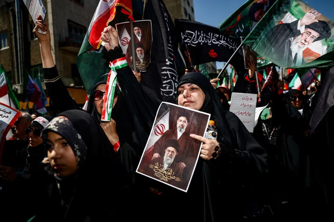 A woman holds a picture of Iran’s late Supreme Leader Ali Khamenei and successor Mojtaba Khamenei during a ceremony marking 40 days since Ayatollah Ali Khamenei was killed.