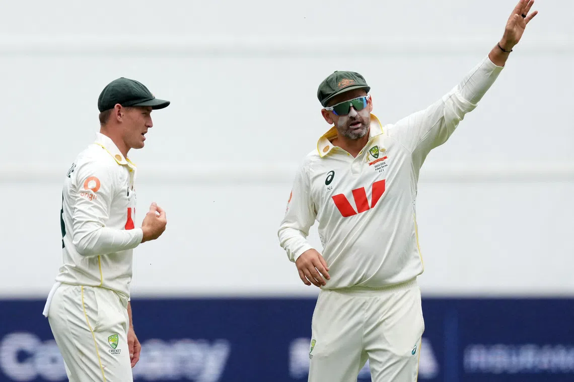 FILE PHOTO: Cricket - The Ashes - Australia v England - First Test - Perth Stadium, Perth, Australia - November 22, 2025 Australia's Nathan Lyon reacts with Marnus Labuschagne REUTERS/Asanka Brendon Ratnayake/ File Photo