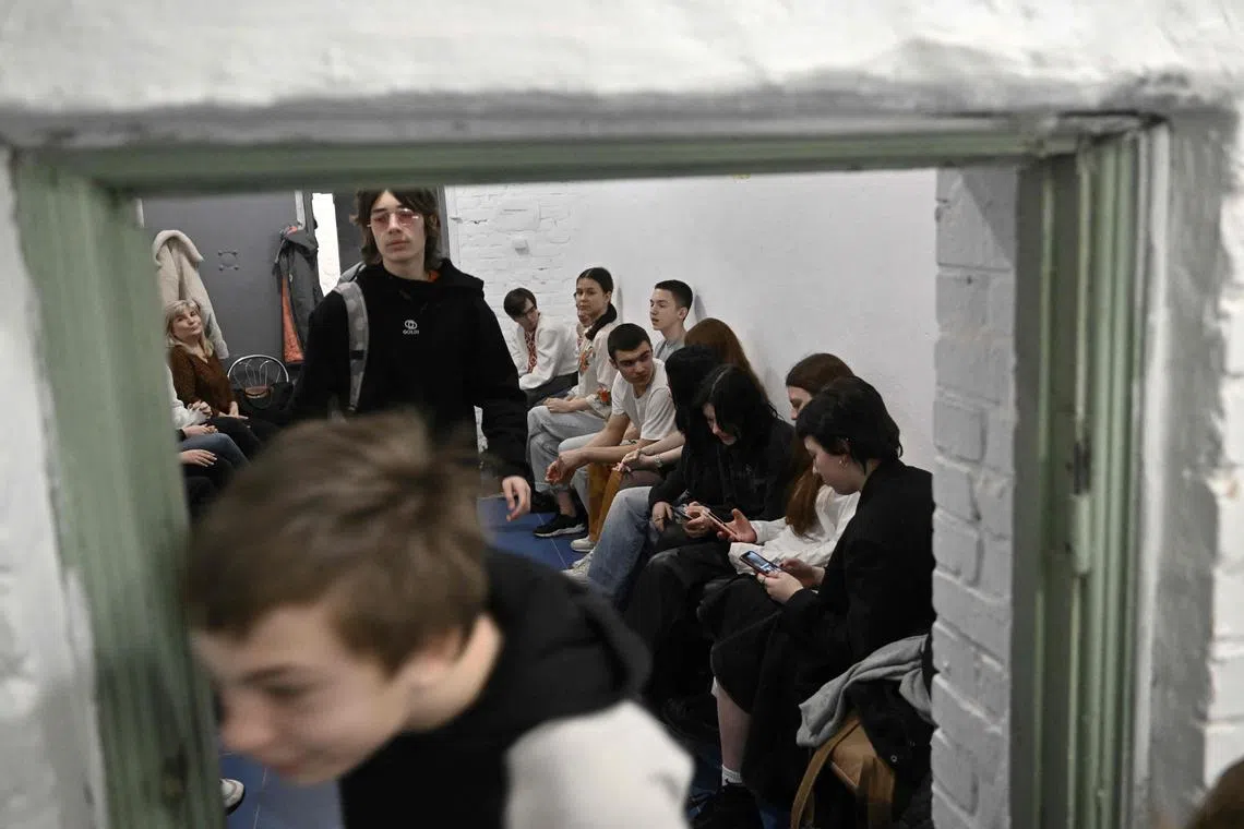 Children study in an air-raid shelter in the cellar of a school after an alarm signal in Kyiv on March 23.