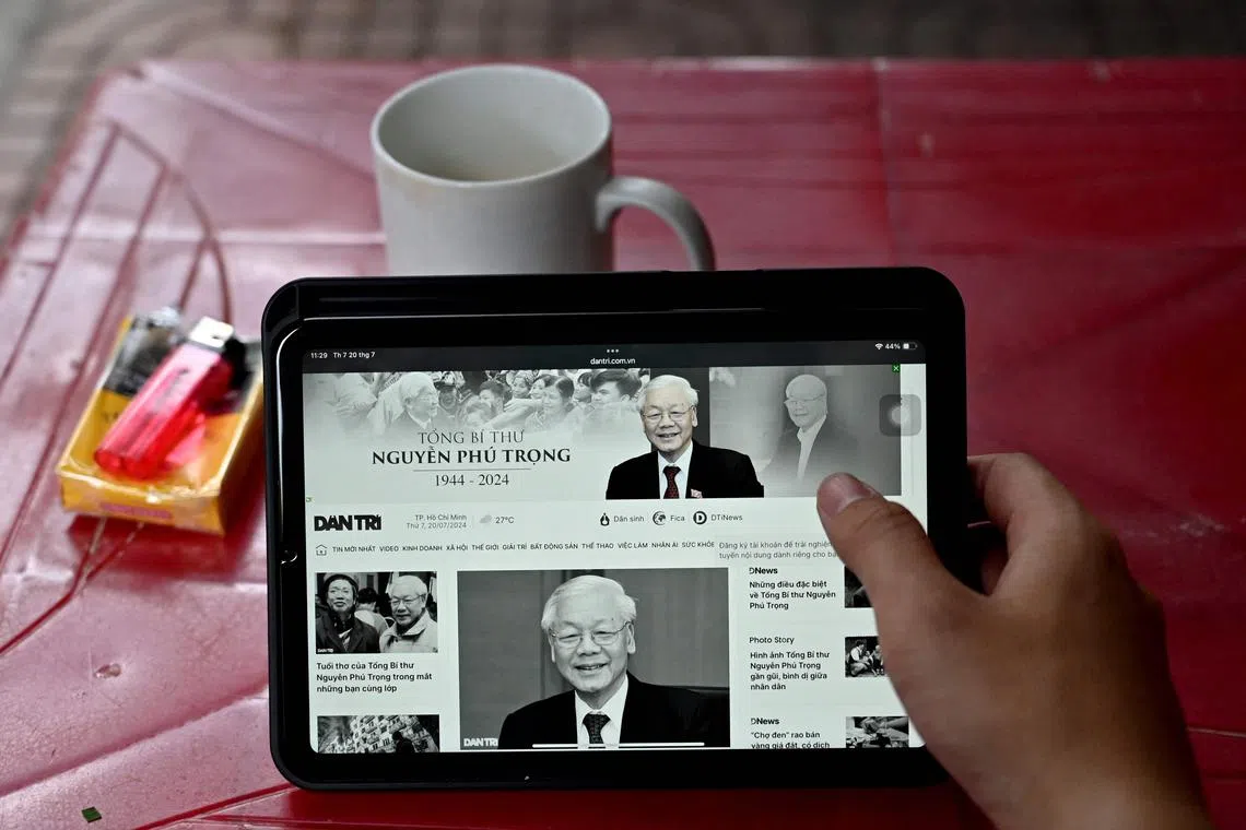 A person reads news reporting on the death of Nguyen Phu Trong, the general secretary of the Communist Party of Vietnam, in Hanoi on July 20, 2024. The general secretary of Vietnam's Communist Party Nguyen Phu Trong -- considered the country's top leader -- died on July 19 aged 80, his party said. (Photo by Nhac NGUYEN / AFP)