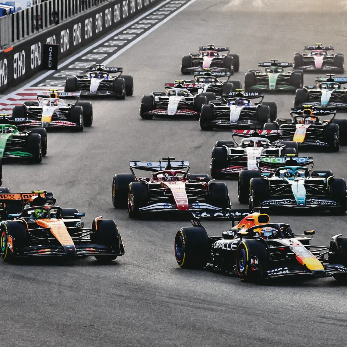 Red Bull's Max Verstappen leads into the first corner at the start of the race ahead of McLaren's Lando Norris during the 2025 Abu Dhabi Grand Prix.
