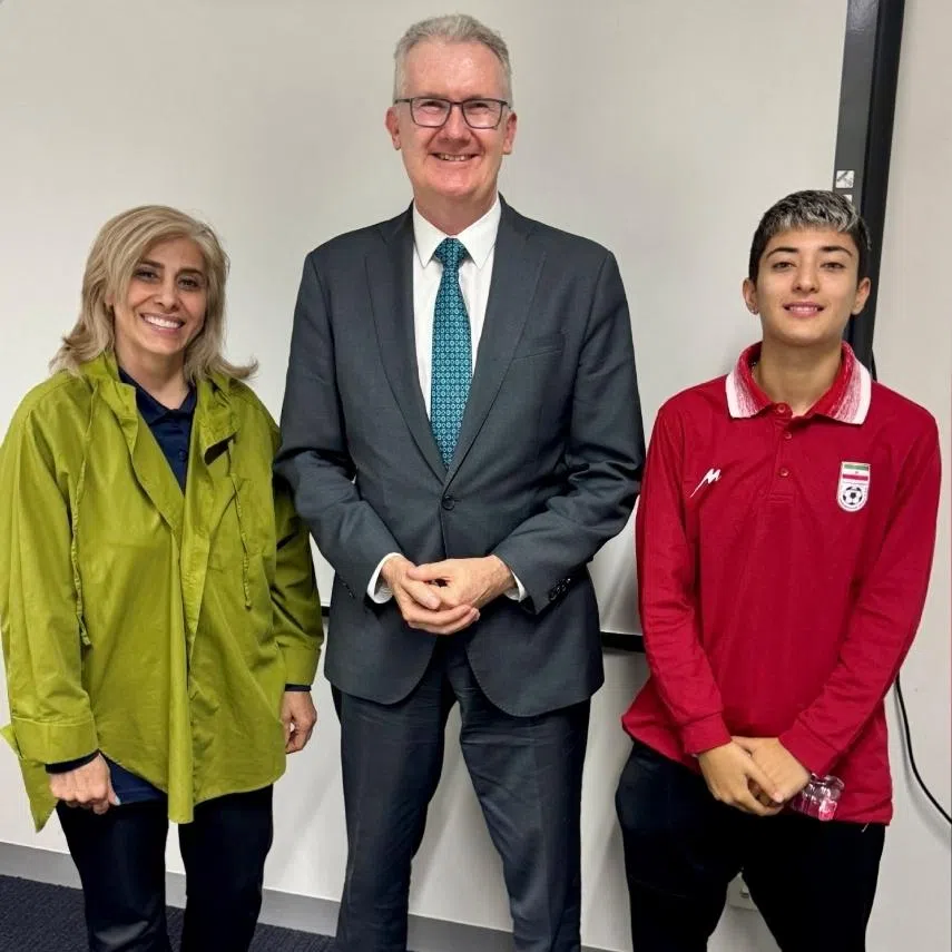 Australia's Home Affairs Minister Tony Burke poses with Iranian women's soccer team support worker Zahra Soltan Meshkeh Kar and team player Mohaddeseh Zolfi, who were granted asylum overnight, in Australia, on March 10.