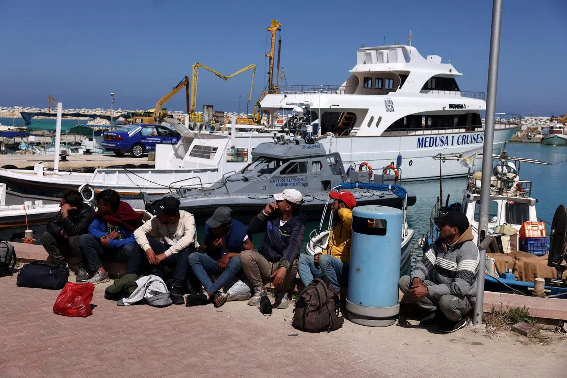 Migrants wait at a fishing shelter in Paralimni, Cyprus, April 5, 2024. This week the island has seen un unprecedented influx of hundreds of refugees from Syria, whom Cypriot authorities said set off from the coast of Lebanon. REUTERS/Yiannis Kourtoglou/ File Photo