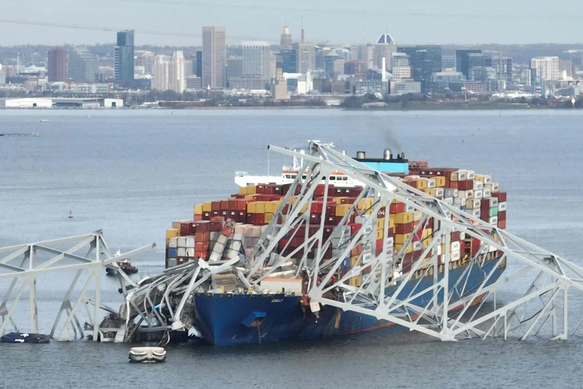 The steel frame of the Francis Scott Key Bridge sits on top of a container ship after the bridge collapsed in Baltimore, Maryland, on March 26, 2024. 