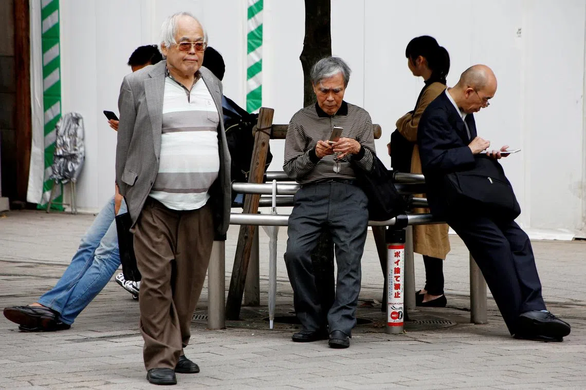 FILE PHOTO: An elderly man uses a mobile phone in front a station in Tokyo, Japan, October 11, 2018.  REUTERS/Kim Kyung-Hoon/File Photo