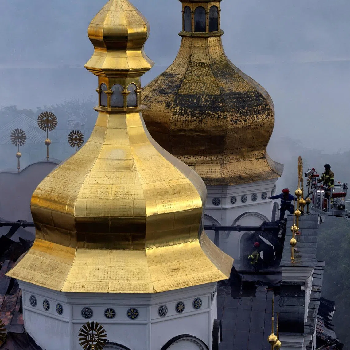 Emergency workers extinguish a fire on the roof of the Dormition Cathedral of the Kyiv Pechersk Lavra, after it was hit during Russian missile and drone strikes, amid Russia's attack on Ukraine, in Kyiv, Ukraine June 15, 2026.  REUTERS/Thomas Peter