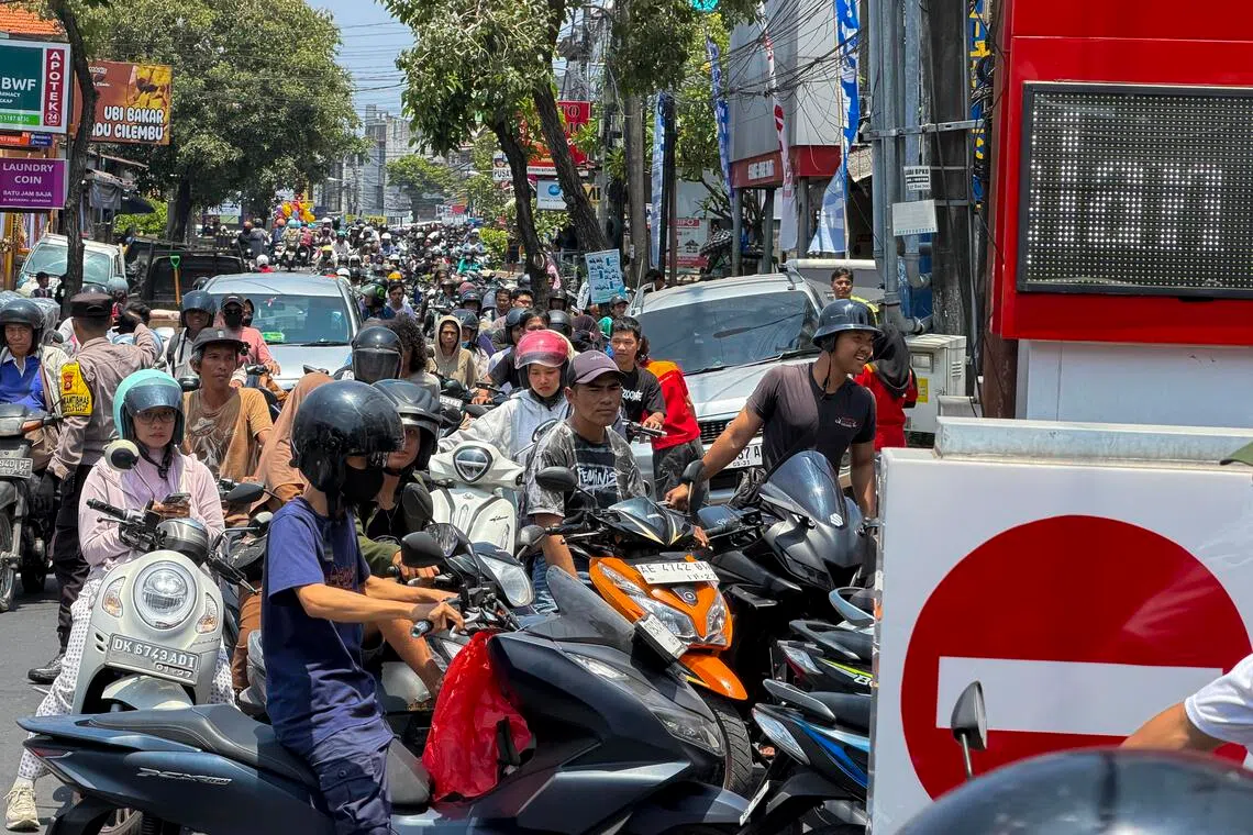 Motorcyclists queueing at a petrol station in Denpasar in Bali on Oct 13.