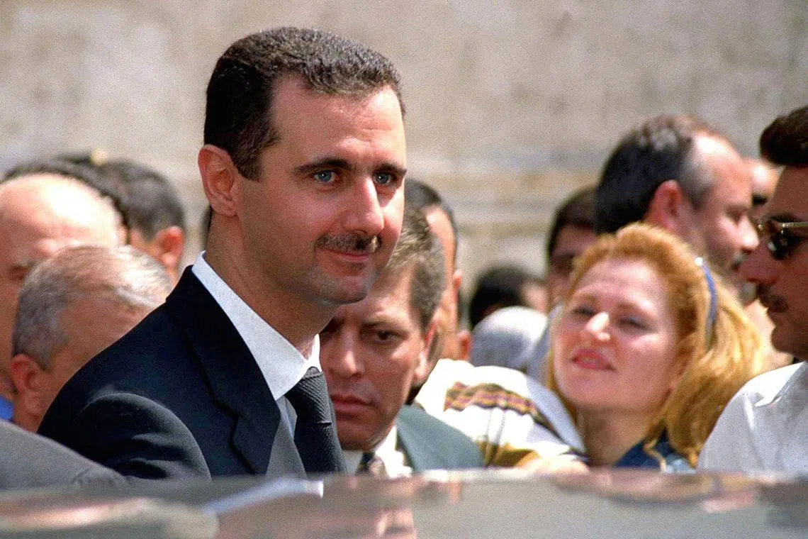 Bashar al-Assad, then 34, smiles at the crowd gathered in front of a polling station in Damascus on July 10, 2000. 