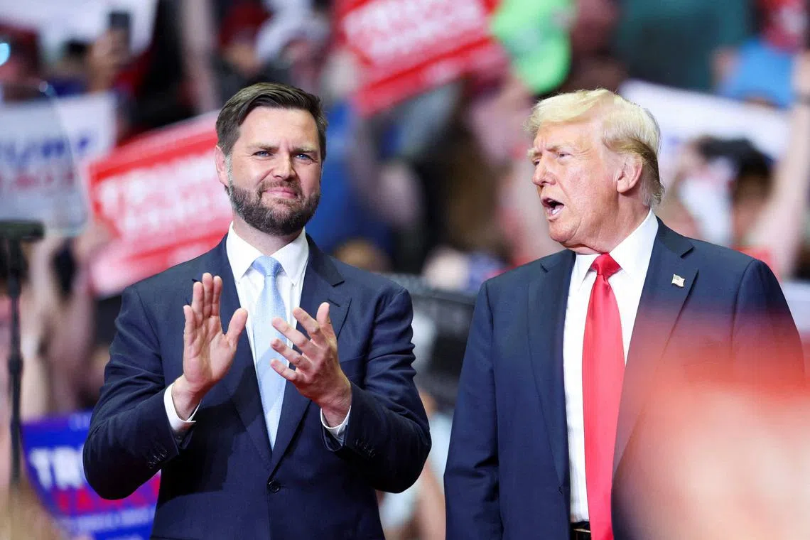 FILE PHOTO: Republican presidential nominee and former U.S. President Donald Trump stands with Republican vice presidential nominee U.S. Senator J.D. Vance (R-OH), as he holds a rally for the first time with his running mate, in Grand Rapids, Michigan, U.S. July 20, 2024. REUTERS/Tom Brenner/File Photo