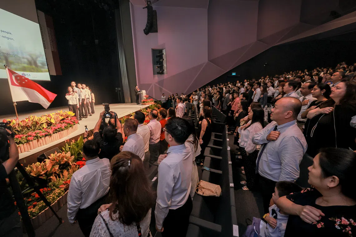 New Singapore citizens recite the National Pledge during the National Citizenship Ceremony on Aug 15.