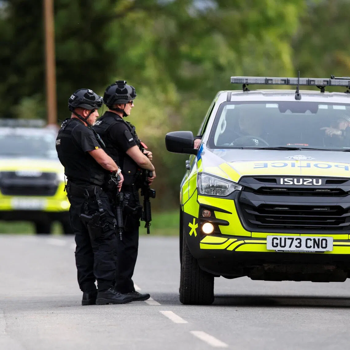 Armed police officers working on a road outside the perimeter of Britain’s RAF Fairford airbase on Sept 28. Counter-terrorism police said a quantity of petrol was recovered from vehicles at the scene.
