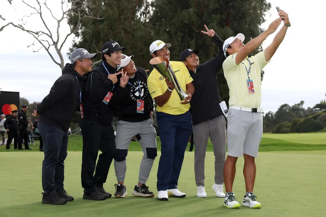 Hideki Matsuyama of Japan posing for a wefie with his caddie Shota Hayafuji and friends after his winning putt on the 18th green during the final round of The Genesis Invitational.