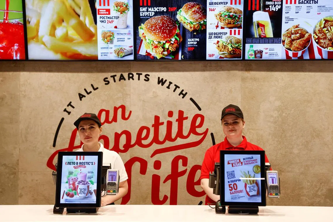 Employees stand at a cashier desk in a former KFC restaurant, which re-opens under the brand Rostic's after American firm Yum!Brands Inc sold its fast food chain KFC in Russia to a local operator, in Moscow, Russia, April 25, 2023. REUTERS/Maxim Shemetov