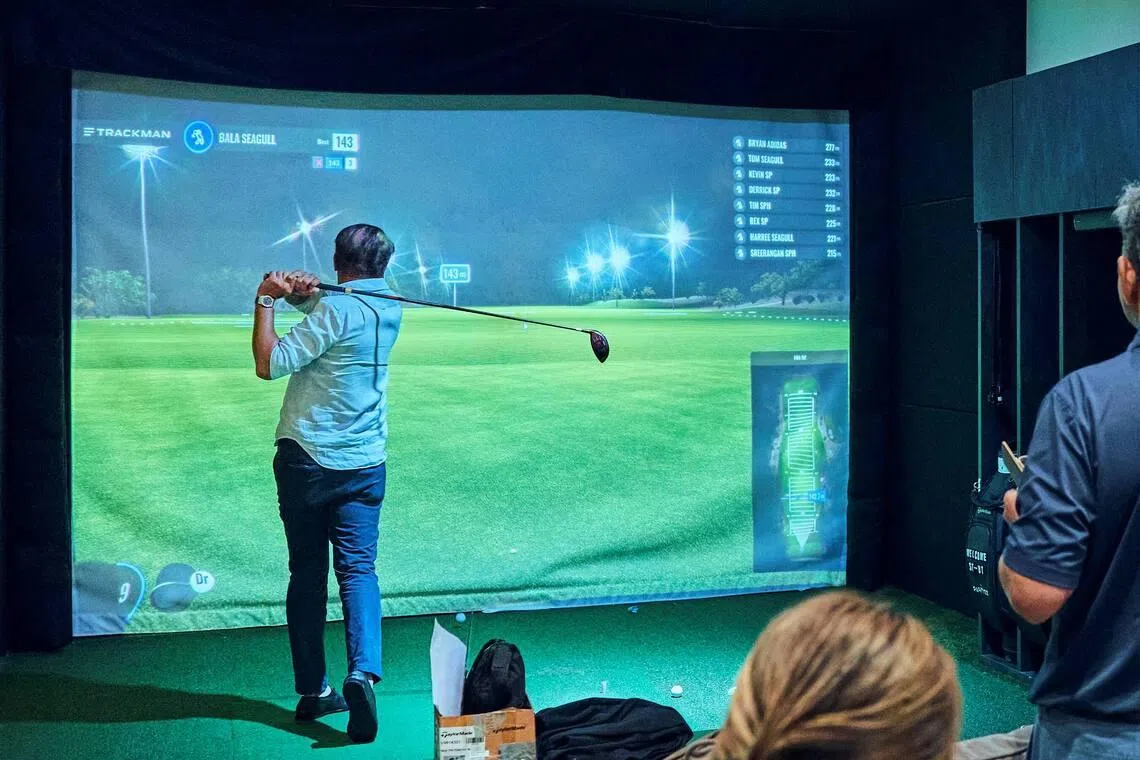 A golfer attending the ST/BT Cortporate Golf Networking Night trying his hand at Partee's simulator at Oasis Science Park.