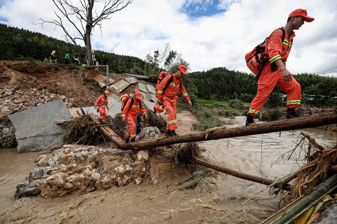 Members of a rescue team walk to a flood-affacted area in Zixing, in central China's Hunan province on July 29, 2024. Seven people died and three were missing after heavy rain and flooding hit central China's Hunan province, state media reported on July 30. (Photo by AFP) / China OUT