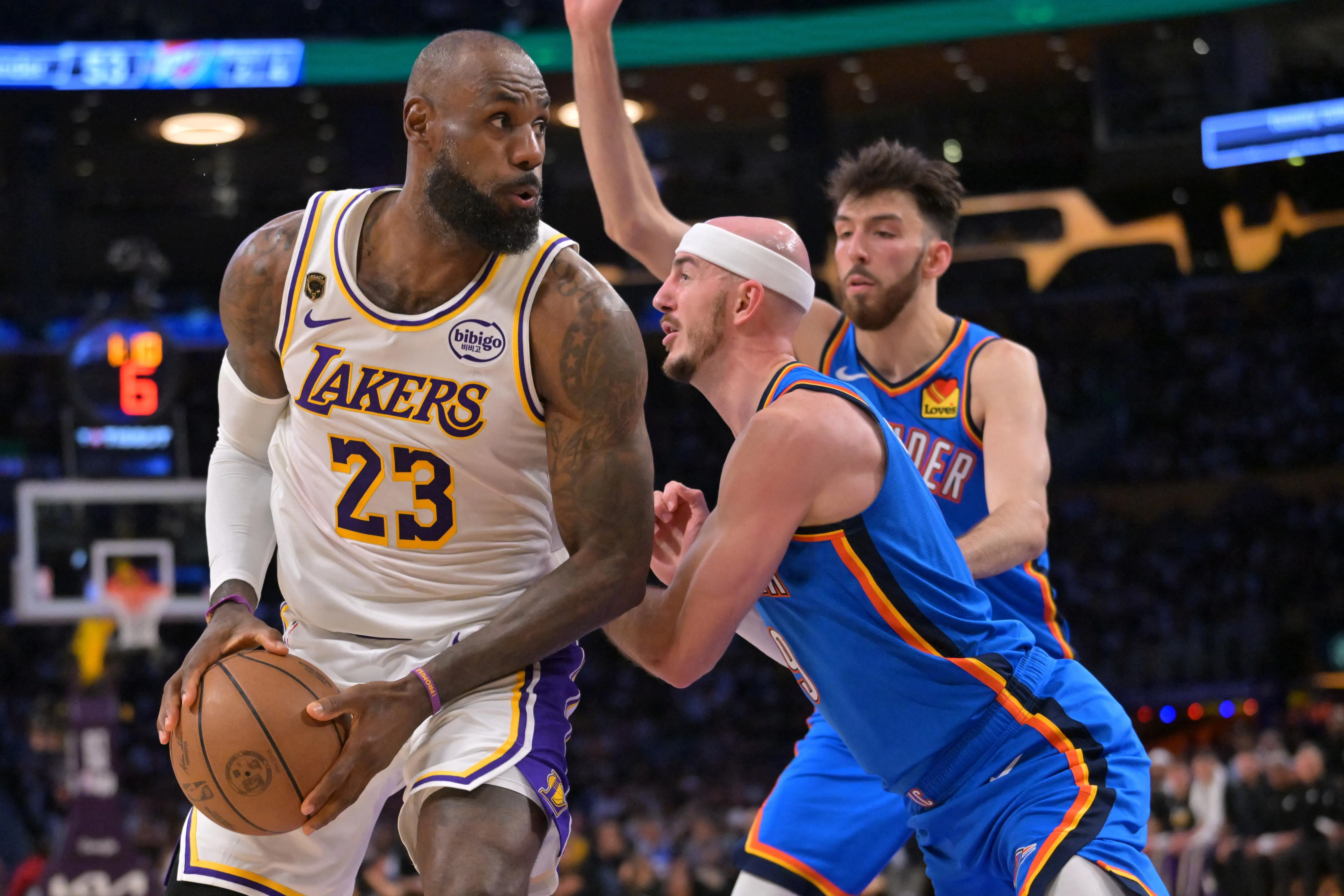 May 9, 2026; Los Angeles, California, USA; Los Angeles Lakers forward LeBron James (23) is defended by Oklahoma City Thunder guard Alex Caruso (9) and center Chet Holmgren (7) in the first half of game three of the second round of the 2026 NBA Playoffs at Crypto.com Arena. Mandatory Credit: Jayne Kamin-Oncea-Imagn Images