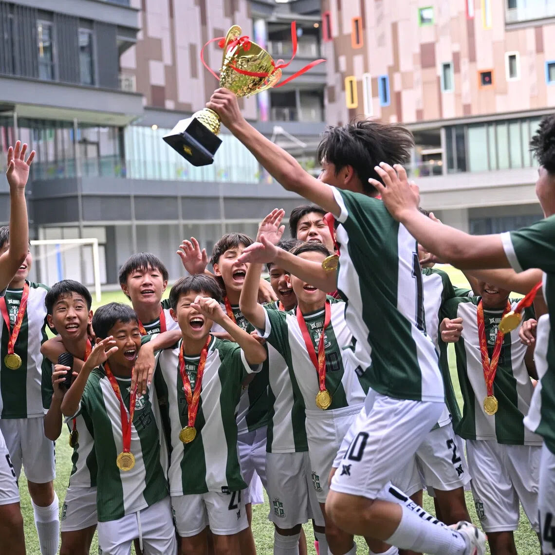 St Joseph’s Institution captain Zayden Ng lifting the trophy during his team’s celebration after they beat St Gabriel’s Secondary School 3-0 to win the C Division boys’ football final for a third straight year.