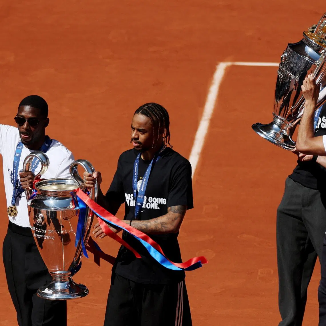 Tennis - French Open - Roland Garros, Paris, France - June 1, 2026 Paris St Germain's Ousmane Dembele, Bradley Barcola, Desire Doue and Warren Zaire-Emery as they present their back-to-back UEFA Champions League trophies to the spectators in the stands after winning the final against Arsenal REUTERS/Stephane Mahe