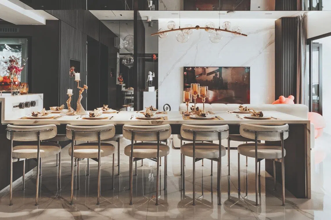 Curved-back chairs and a statement light add to the ambience in the dining area.