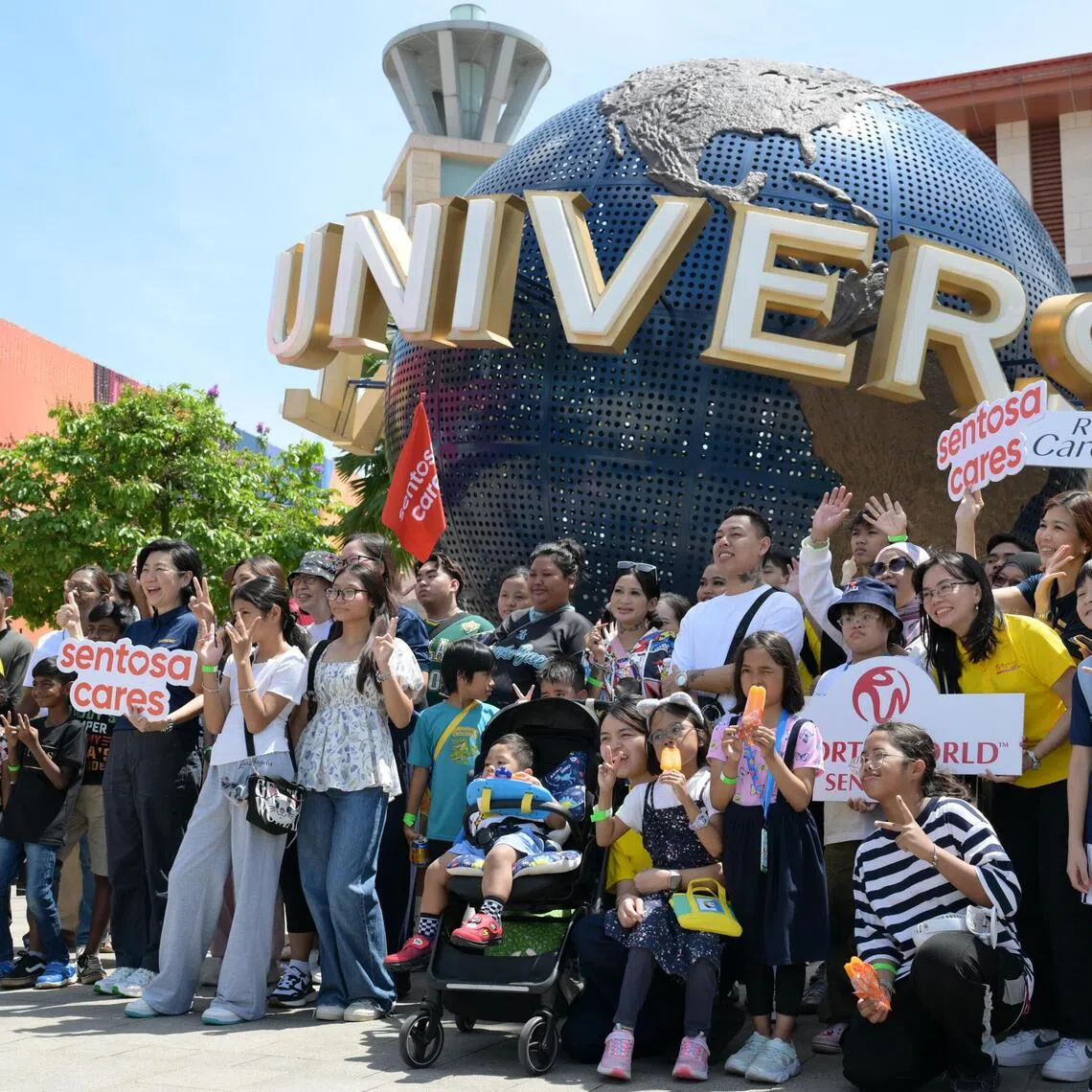 Some of the beneficiaries and their families from The Straits Times School Pocket Money Fund (STSPMF) together with volunteers from RWS and SDC at Universal Studios Singapore on Nov 29, 2025.