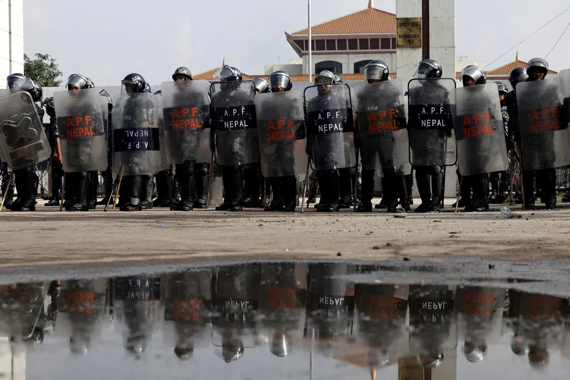 FILE PHOTO: Police officers in riot gear stand guard outside the Parliament during a curfew following a protest against corruption and government’s decision to block several social media platforms, in Kathmandu, Nepal, September 9, 2025. REUTERS/Navesh Chitrakar/File Photo