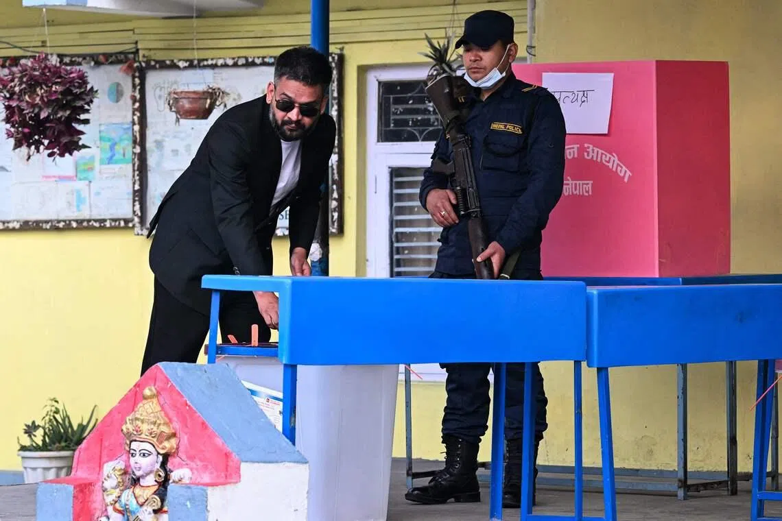 Rastriya Swatantra Party election candidate Balendra Shah (left) casts his ballots as he votes at a polling station in Kathmandu on March 5.
