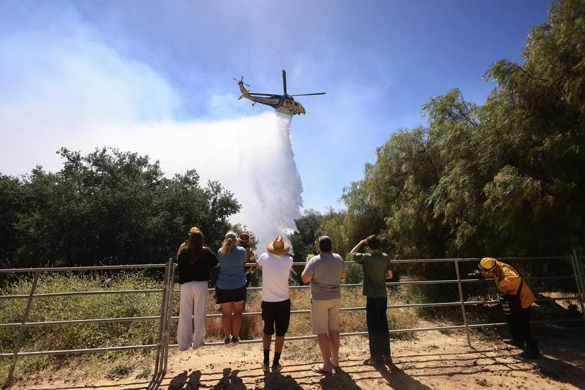 A helicopter dropping water to battle a wildfire known as the Sandy Fire, in Simi Valley, California, U.S. on May 18, 2026. 