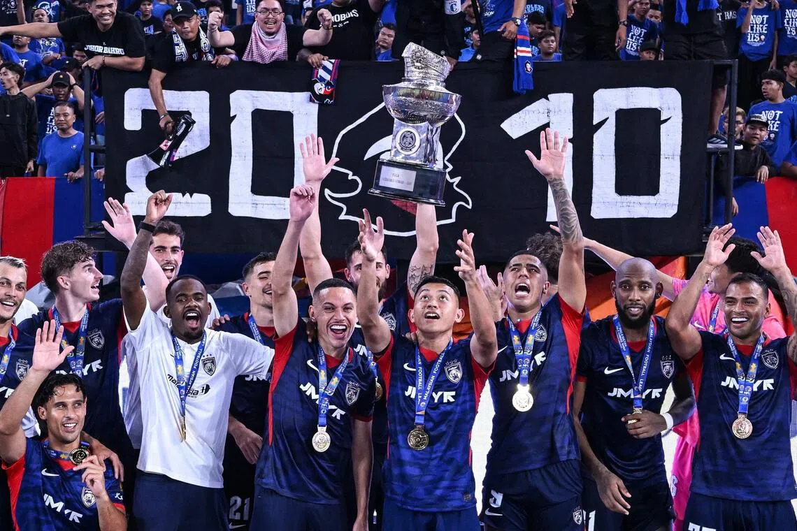 Johor Darul Ta’zim’s players celebrating with the trophy after beating Kuching City in the opening football match of the Malaysia Super League on Aug 21.