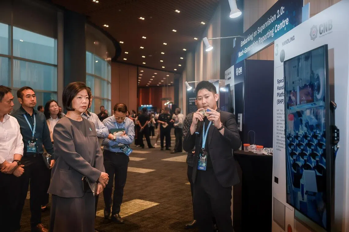 Senior Minister of State for Foreign Affairs and Home Affairs Sim Ann views the Central Narcotics Bureau’s “Next-Generation Reporting Centre” at the exhibition during the Central Narcotics Bureau Workplan Seminar 2026.