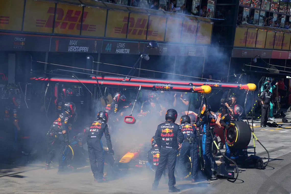 Mechanics deal with the smoke coming out of Red Bull Formula One car, driven by Dutch driver Max Verstappen, during the Australian Grand Prix on March 24.