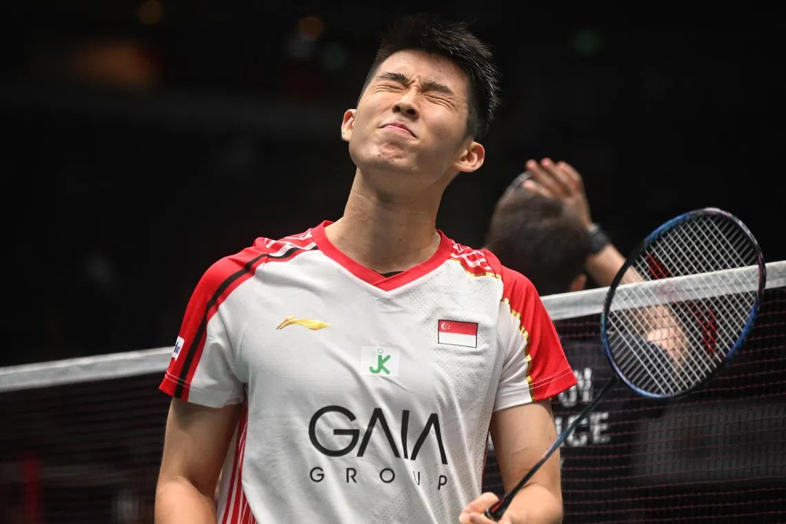 Loh Kean Yew (in white), rues a demoralising second round defeat to Christo Popov (in black) at the Singapore Badminton Open at Indoor Stadium on Jun 8, 2023.