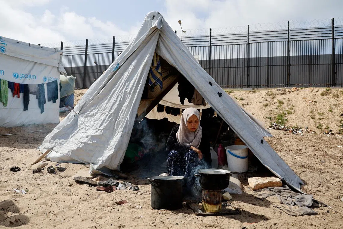 A displaced Palestinian woman, who fled her house due to Israeli strikes, sits at a tent camp, amid the ongoing conflict between Israel and the Palestinian Islamist group Hamas, in Rafah in the southern Gaza Strip, March 6, 2024. REUTERS/Mohammed Salem