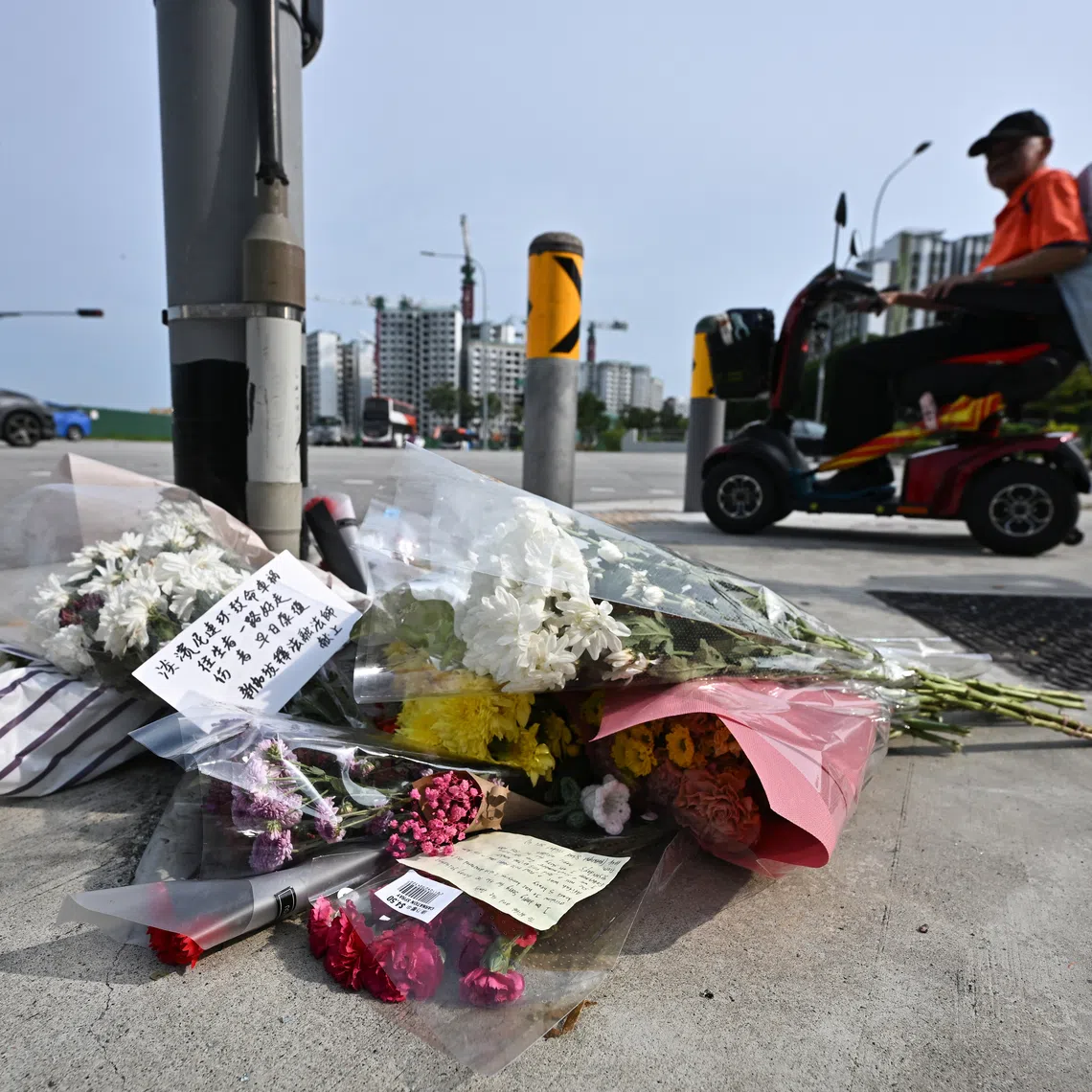 Bouquets of flowers placed below the traffic light near the accident site at Tampines Avenue 4 on April 23, 2024.