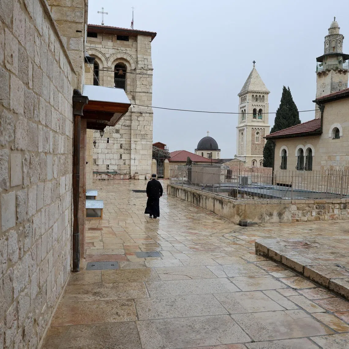 A person walks near the Church of the Holy Sepulchre as it's locked following the cancellation of the traditional Palm Sunday procession from the Mount of Olives.