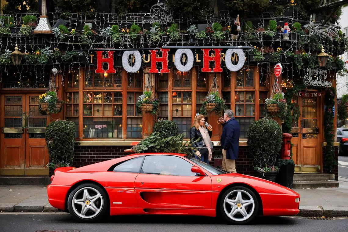 Pub-goers drinking outside The Churchill Arms, which is decorated for Christmas, in London, Britain, Dec 17, 2024. 