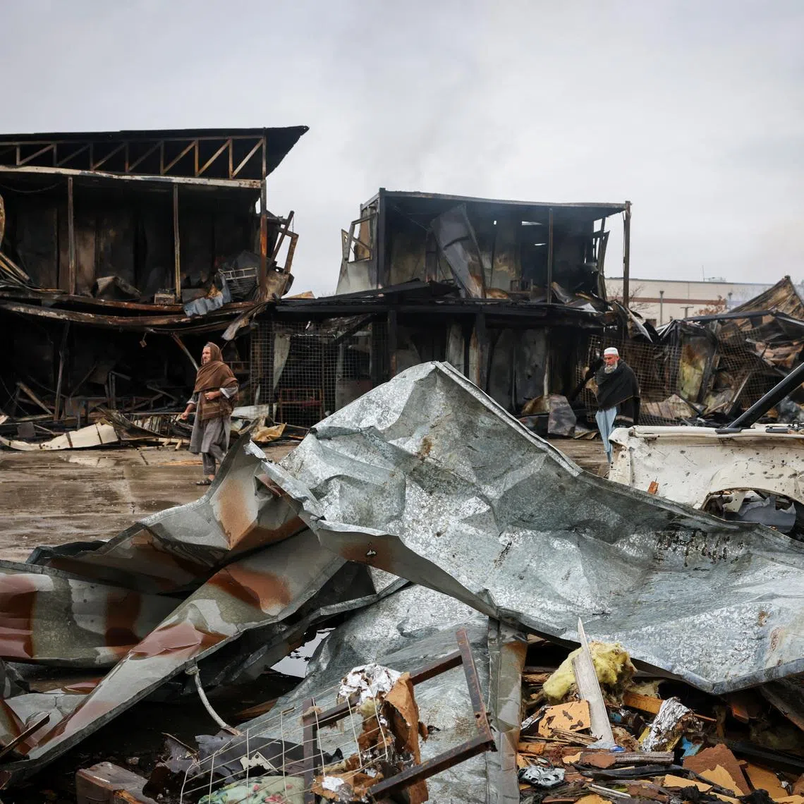 FILE PHOTO: Afghan men walk next to debris lying at the site of a drug rehabilitation center destroyed in what the Taliban said was a Pakistani air strike in Kabul, Afghanistan, March 18, 2026. REUTERS/Sayed Hassib/ File Photo
