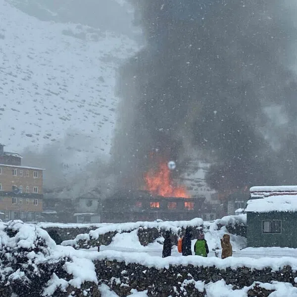 Onlookers watch as a fire guts Hotel Good Luck, which lies along a route leading to the Mount Everest base camp.