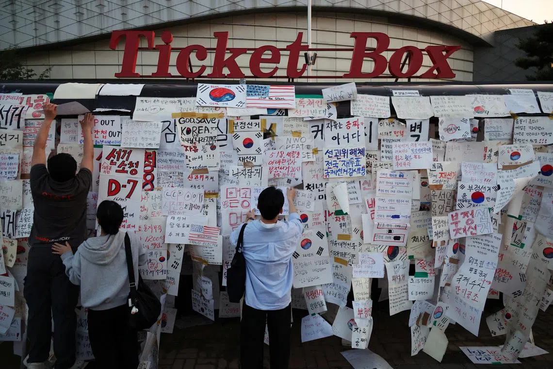 Protesters attach hand-written signs outside a vote-counting centre during a protest to demand a rerun of the local election, amid a ballot paper shortage that disrupted voting, in Seoul, South Korea, June 10, 2026. REUTERS/Kim Hong-Ji