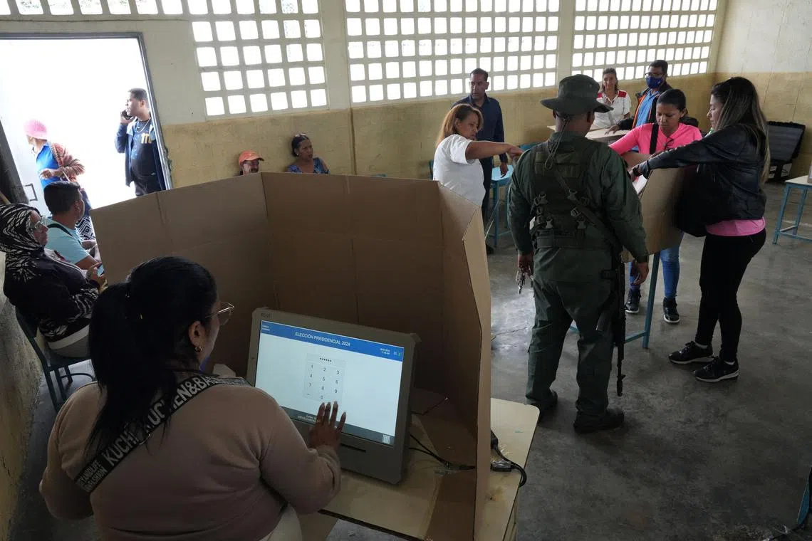 A soldier and volunteers prepare a voting station at a school ahead of Venezuela's presidential election on July 28, in Caracas, Venezuela July 26, 2024. REUTERS/Alexandre Meneghini