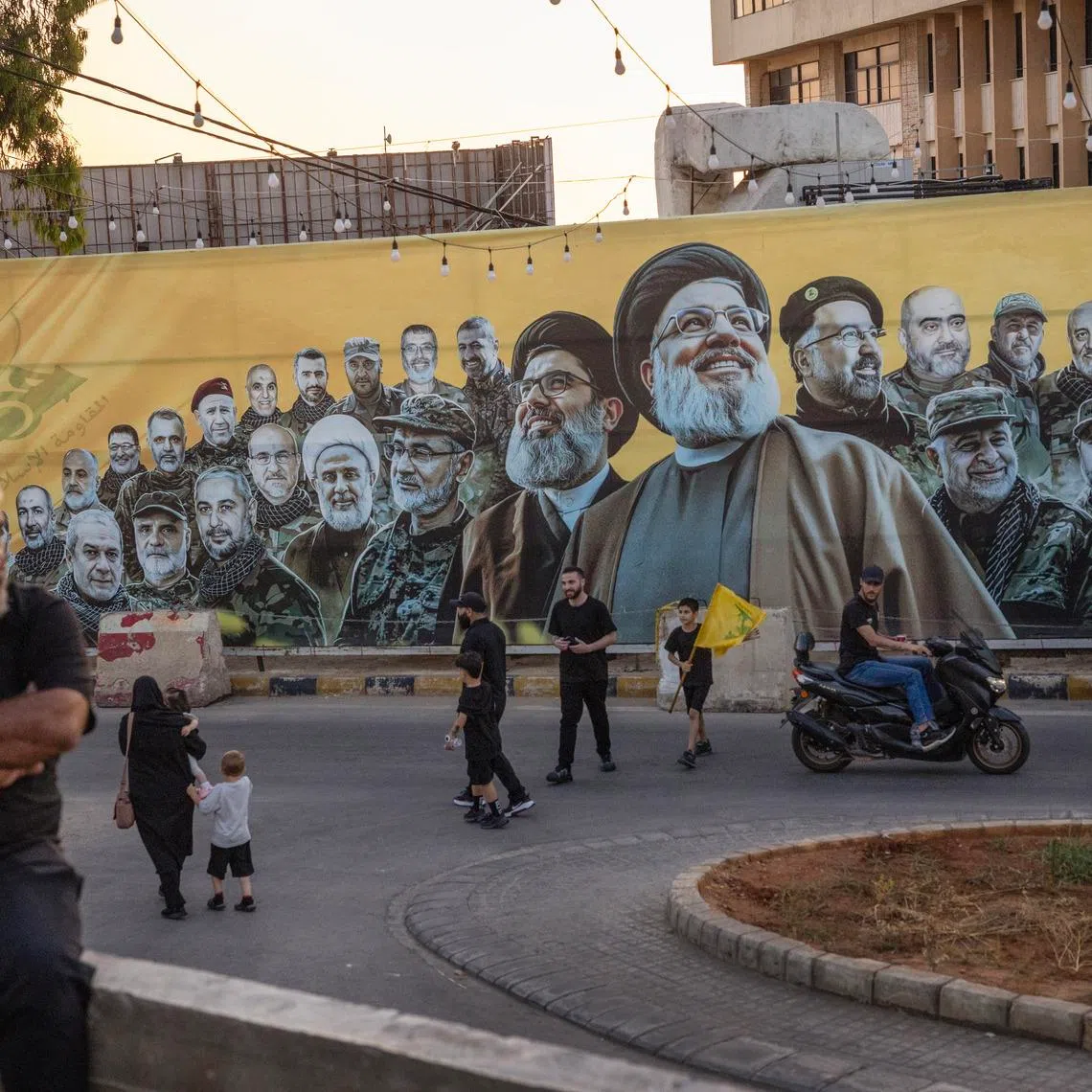 Supporters pass by a billboard showing leaders of Hezbollah in Beirut, Lebanon, on June 17.