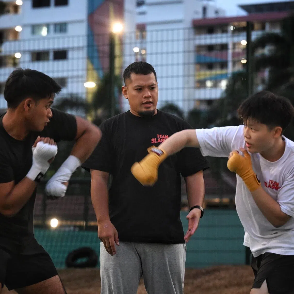 Boxing coach Syafiq Samad (centre) with his boxers Khris Azli (left) and Kiefer Lim, during training on Feb 4, 2026.