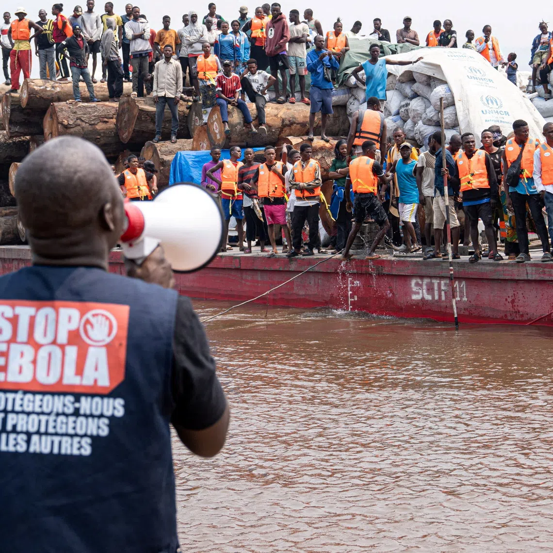 FILE PHOTO: A volunteer uses a megaphone to make announcements while intercepting a passenger boat, after, according to officials, a passenger who had disembarked earlier died after developing symptoms consistent with Ebola, in a place given as Kinshasa, Democratic Republic of the Congo, in this handout image released on August 5, 2026. International Organization For Migration/Handout via REUTERS/ File Photo