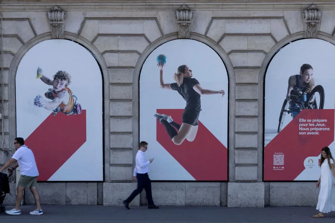 FILE PHOTO: People walk past posters of athletes ahead of the Paris 2024 Summer Paralympic Games in Paris, France, August 27, 2024. REUTERS/Umit Bektas/File Photo