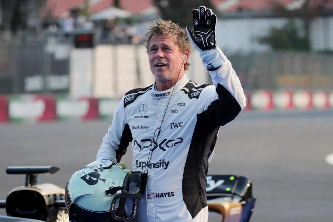 Hollywood star Brad Pitt waves at fans during filming for an F1-inspired movie. Love scammers posing as Pitt recently scammed a French woman out of over S$1.17 million.