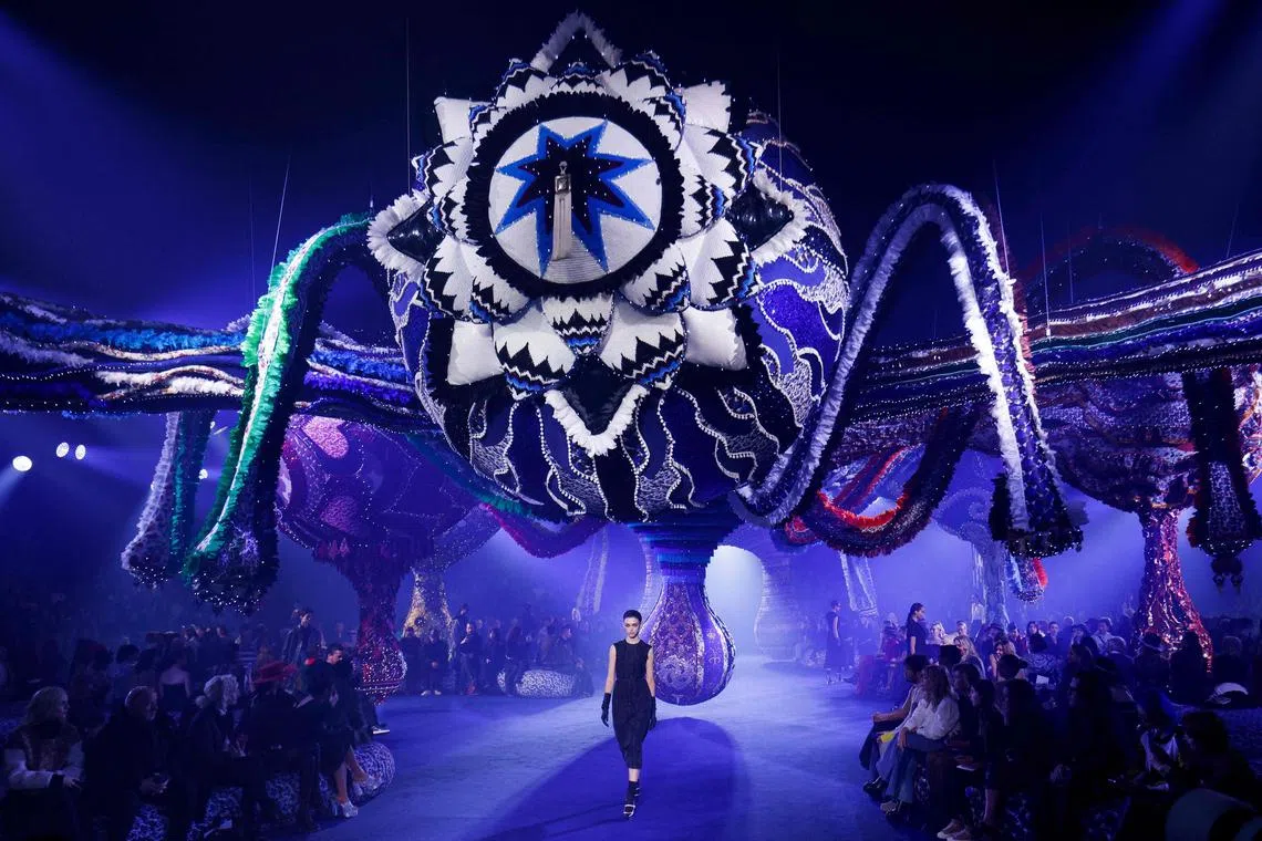 Moody organ music kicked off the show, as models wound around a tent in Paris' Tuileries Gardens, under a massive, hanging set.