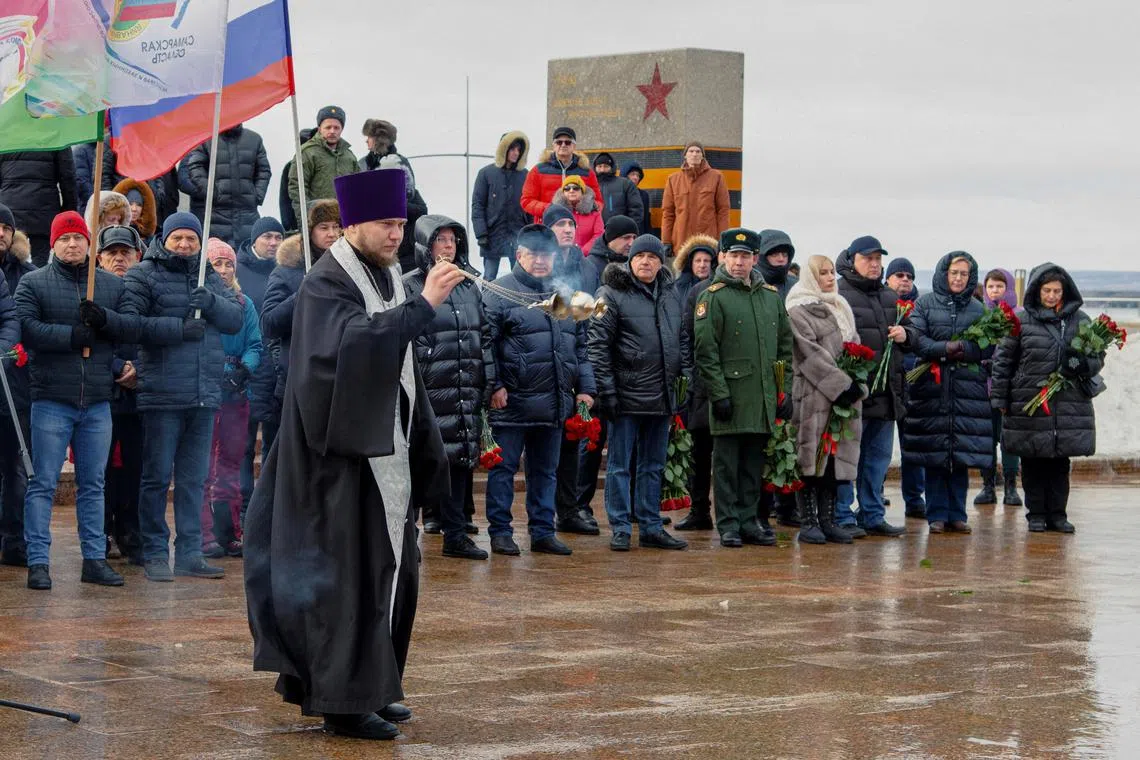 A priest conducts a service during a ceremony in memory of Russian soldiers killed in the course of Russia-Ukraine military conflict in Glory Square in Samara, Russia, on Jan 3, 2023. 