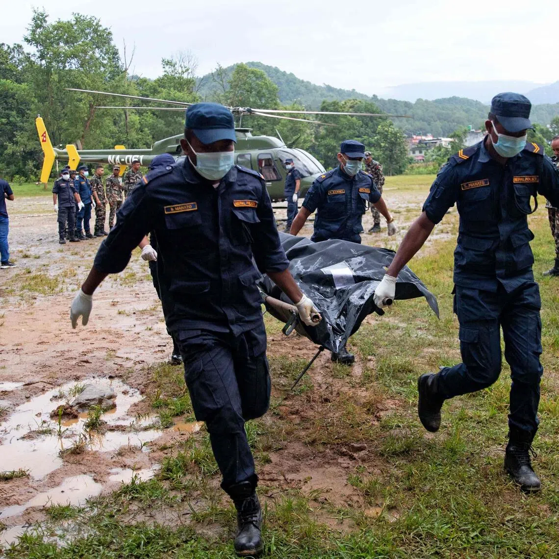 Nepali Army personnel carry bodies of victims during rescue operations after flash floods in Nuwakot district on Aug 28.