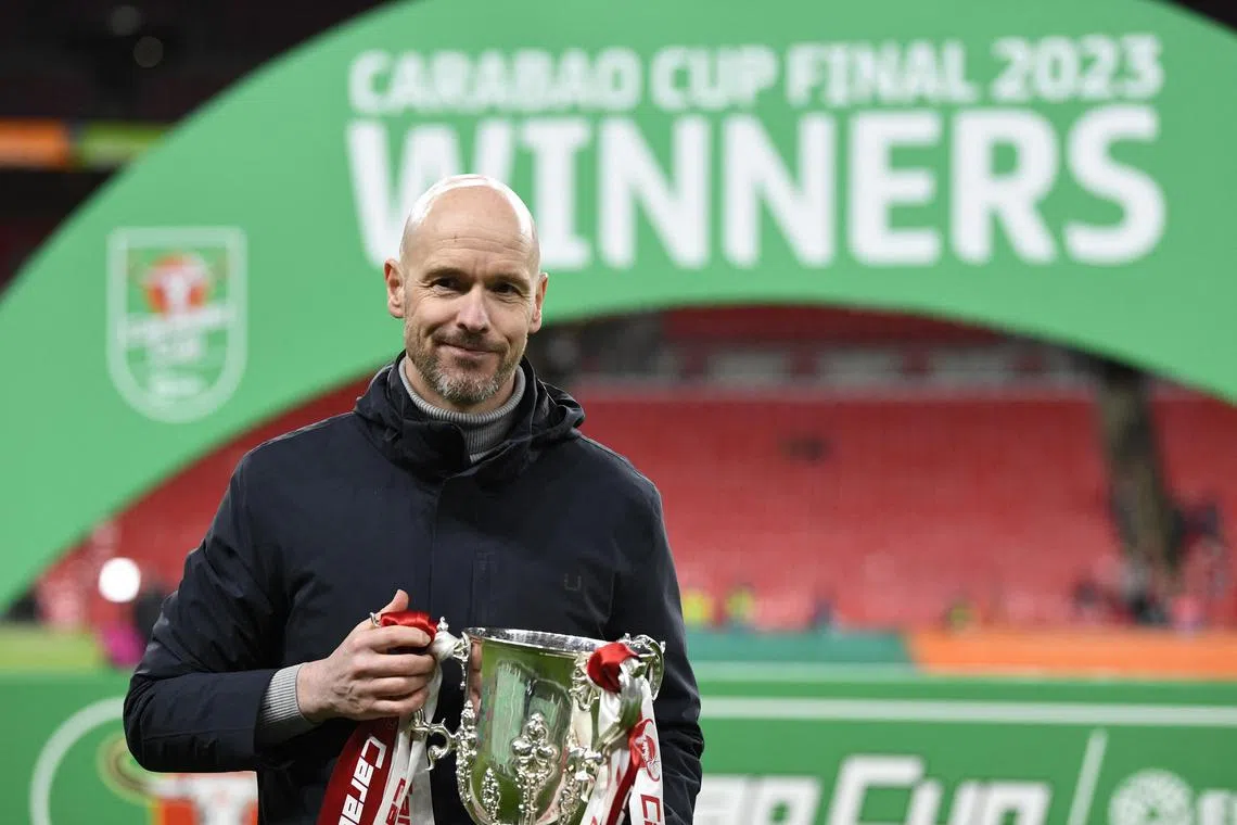 Manchester United manager Erik ten Hag celebrating with the trophy after winning the League Cup.