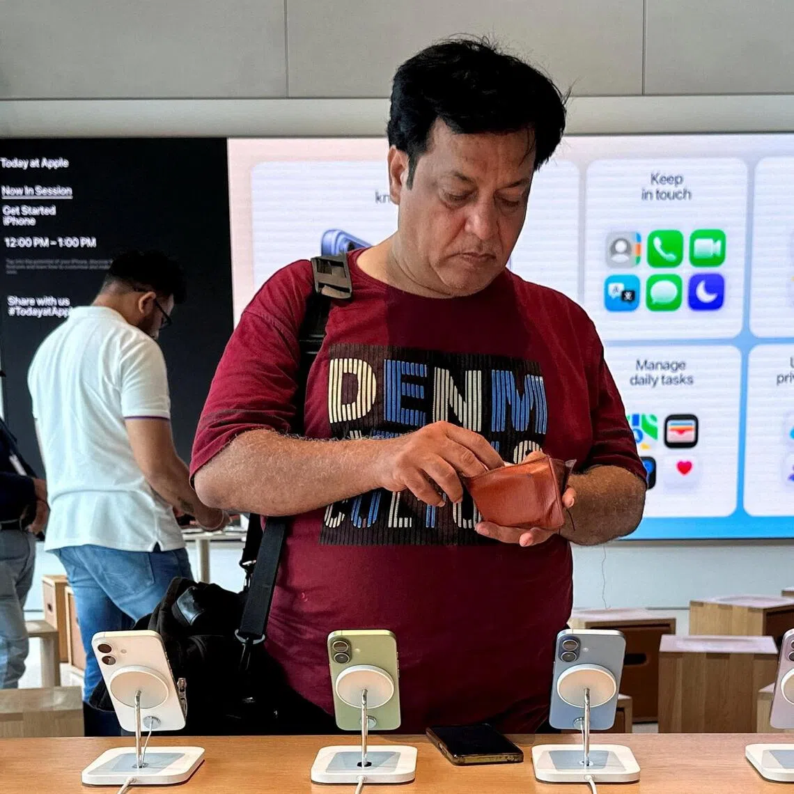 A man checks his wallet at an Apple store in Mumbai, India, on June 29.