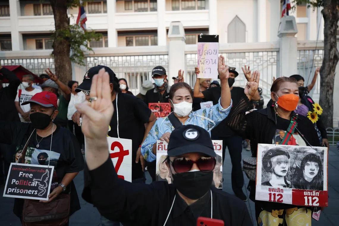 epa10488218 Protesters flash the defiant three-finger salute and hold banners calling for the abolition of the section 112 criminal code (lese-majeste law) and free political prisoners during a demonstration to support the hunger strike of two activists outside the Supreme Court in Bangkok, Thailand, 24 February 2023. Two young activists accused of lese-majeste, Tantawan Tuatulanon and Orawan Phupong, began a hunger strike on 18 January 2023 calling to reform the justice system, abolish the lese-majeste law, and release political prisoners detained on royal defamation charges.  EPA-EFE/RUNGROJ YONGRIT